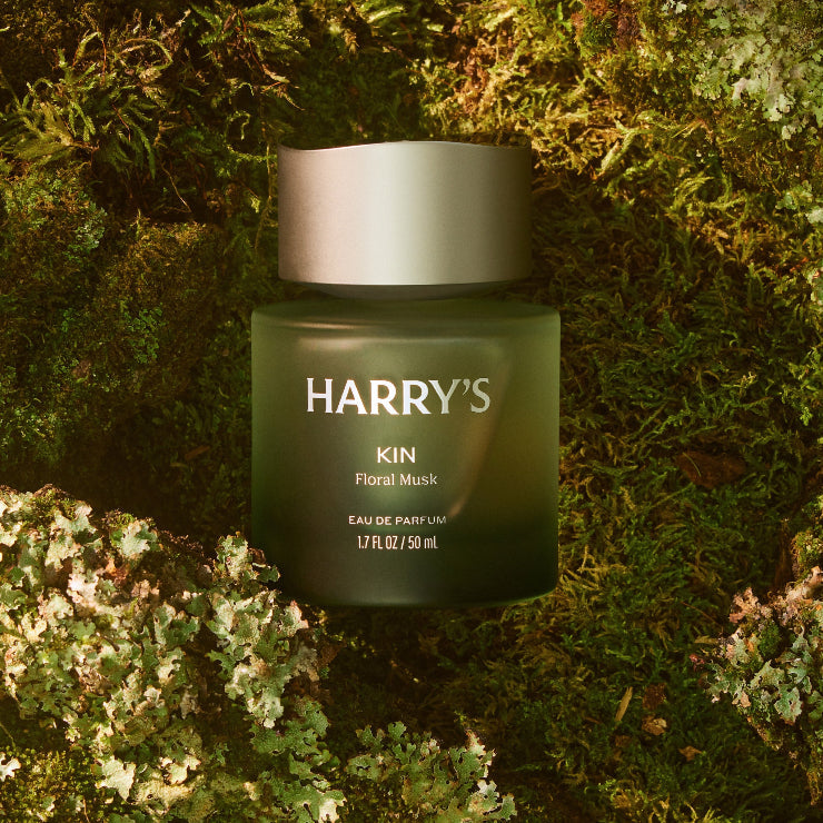 Green cologne bottle with silver cap labeled 'HARRY'S' on a textured green background