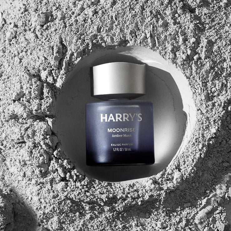 Harry's Moonrise Amber Musk cologne bottle on a textured stone surface