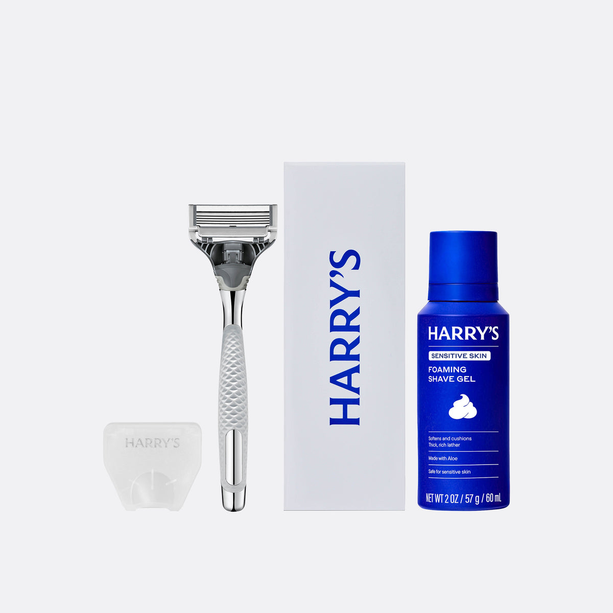 Harry's grooming kit with razor, shaving gel, and brush on a white background