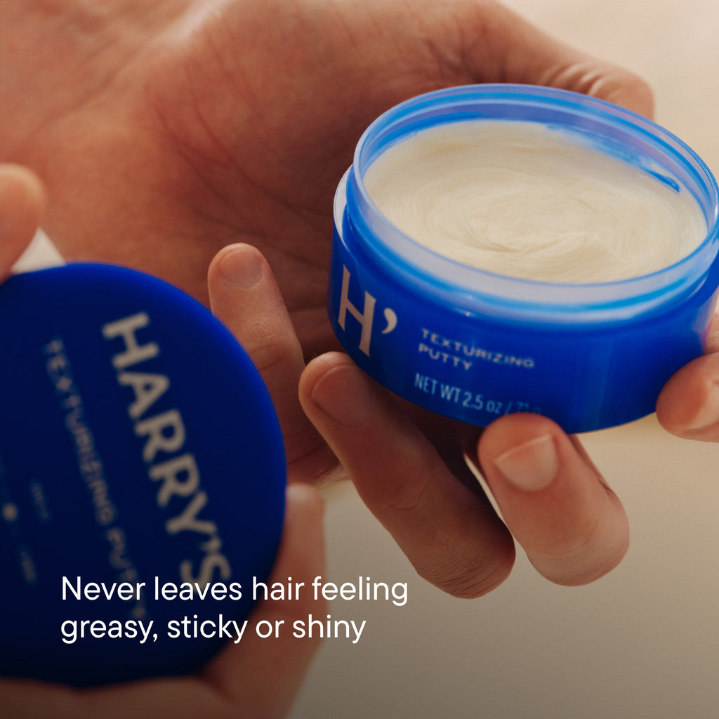Two jars of hair product held by a hand with text highlighting benefits.