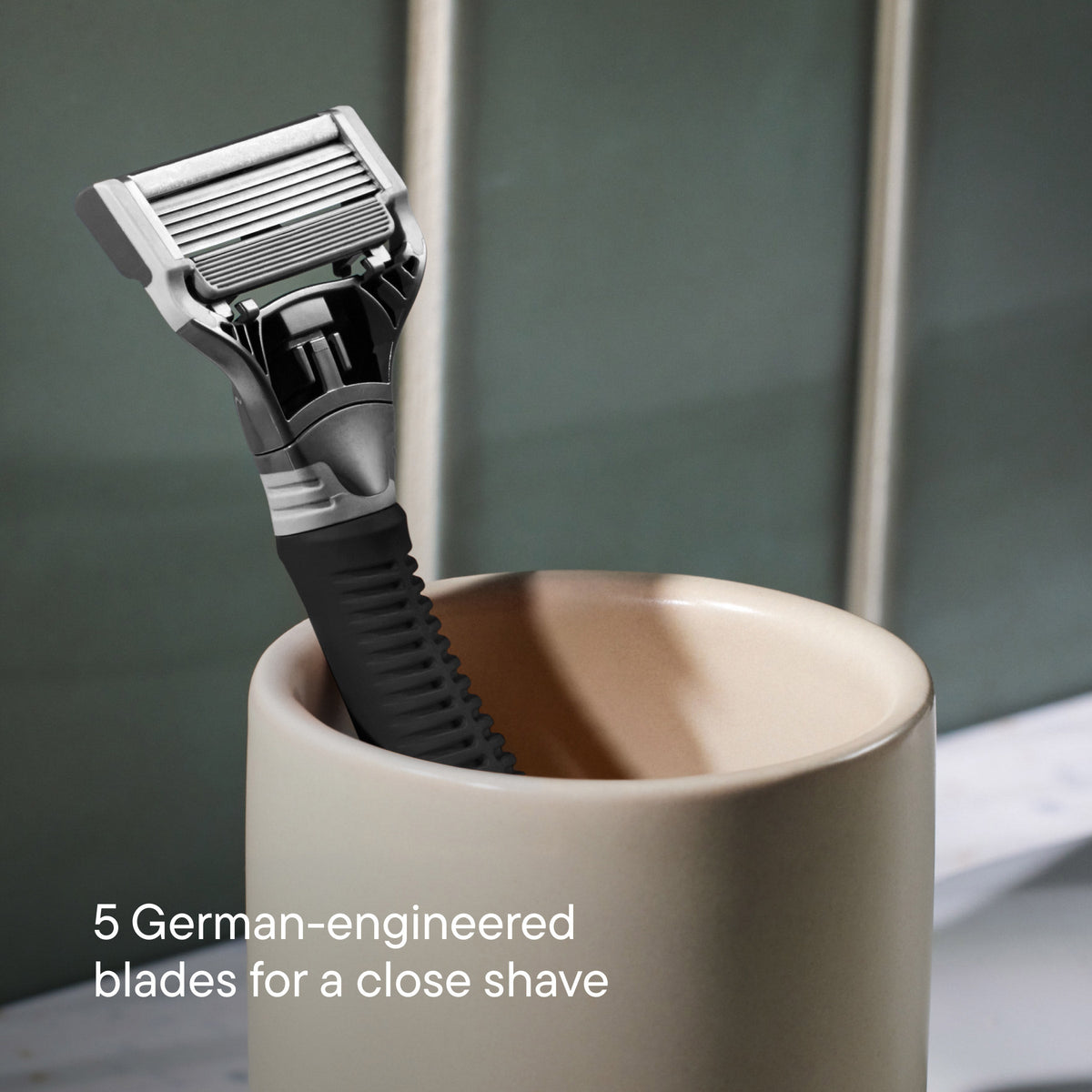 Grey Truman razor resting in an off white ceramic cup.