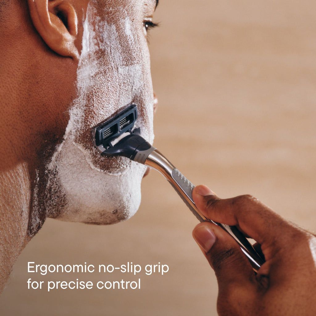 Person shaving their face with a razor, emphasizing ergonomic design.
