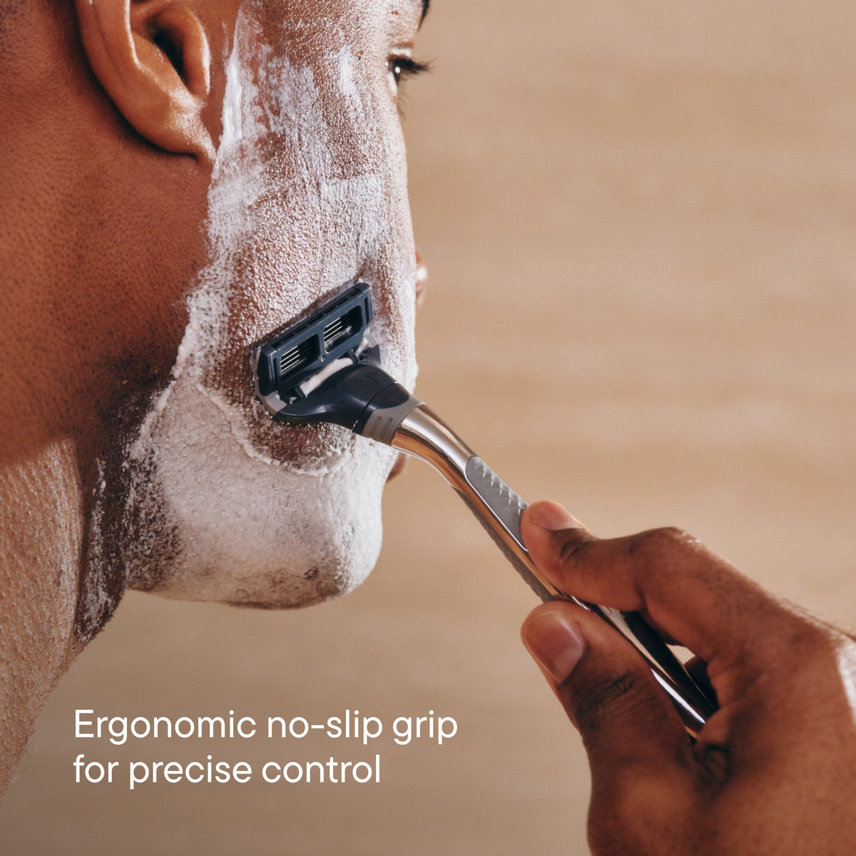 Person shaving their face with a razor, emphasizing ergonomic design.