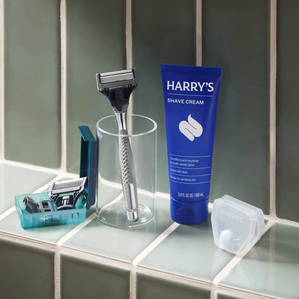 Shave cream tube and razor on a bathroom counter.