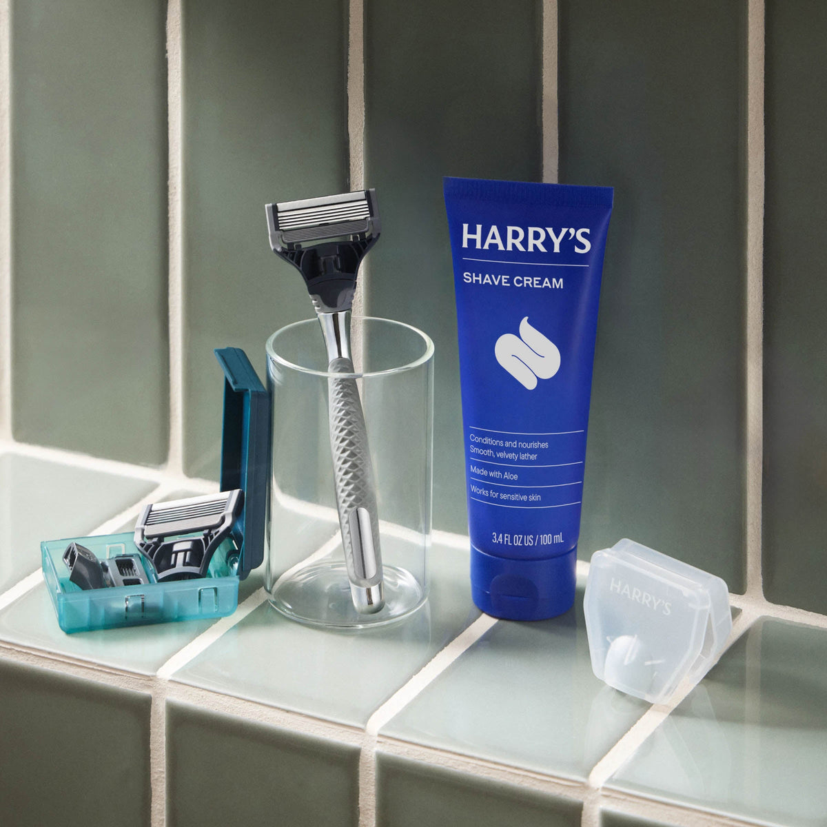 Shave cream tube and razor on a bathroom counter.