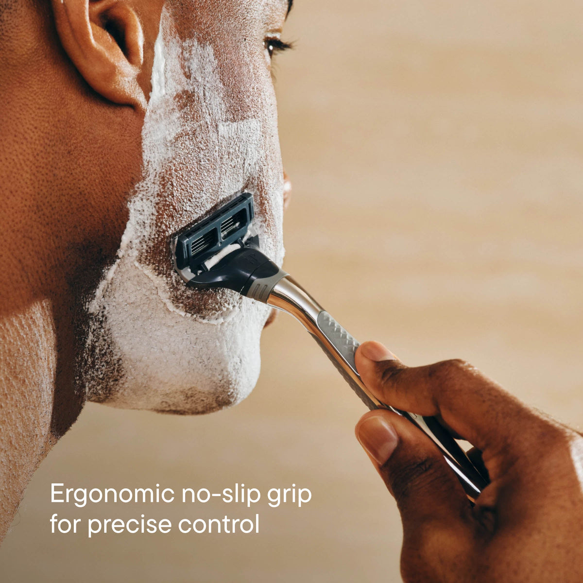 Person shaving their face with a razor, emphasizing ergonomic design.