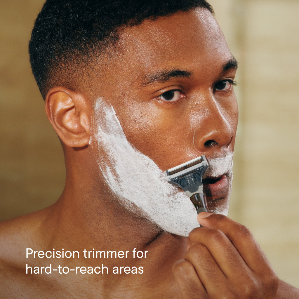 Man shaving with a precision trimmer on a blurred background